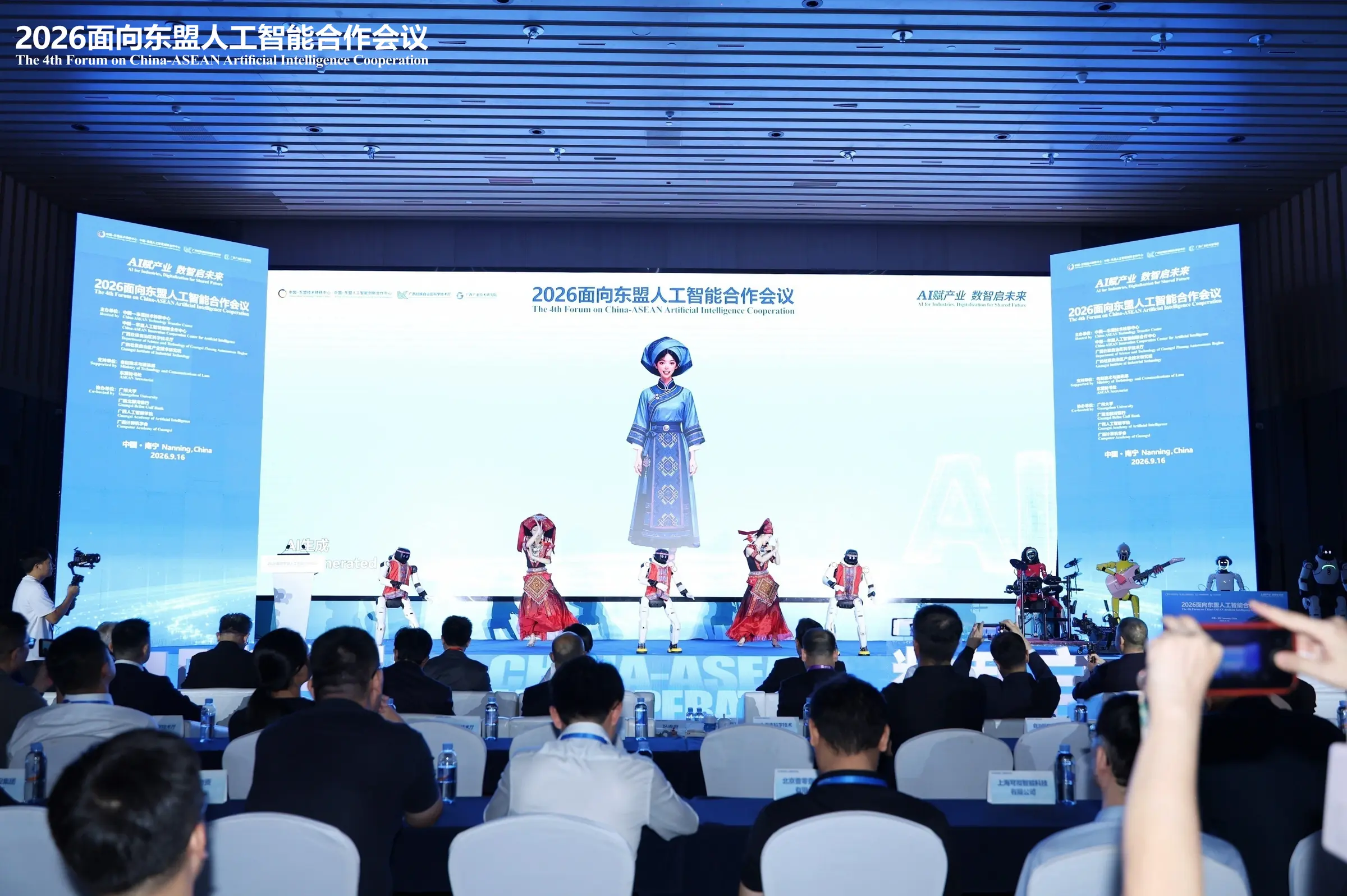 2026面向东盟人工智能合作会议开幕式现场，舞台右侧机器人乐队与现场观众同框