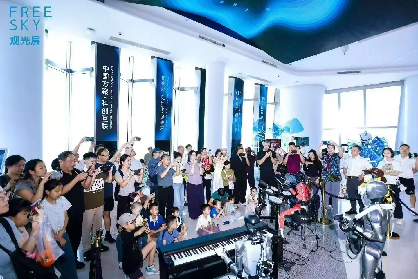 深圳平安金融中心观光层观众观看机器人乐队演出的现场照片
